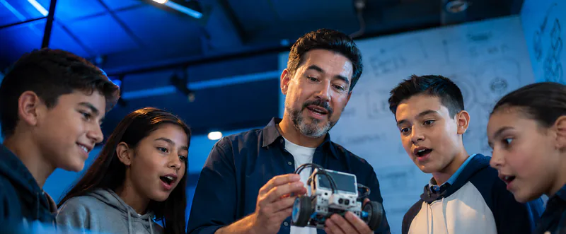 Docente guiando a estudiantes en un taller de robótica